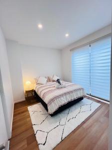 a bedroom with a bed and a large window at Double storey, Walk to Showground in Melbourne
