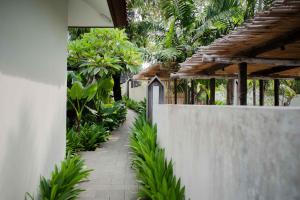 a garden path with a fence and trees at Ecozy Dijiwa Canggu in Canggu