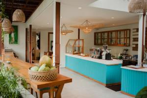 a kitchen with blue cabinets and a basket of fruit on a table at Ecozy Dijiwa Canggu in Canggu