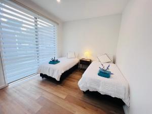 Duas camas num quarto branco com uma janela em Double storey, Walk to Showground em Melbourne