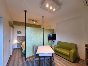 ein Wohnzimmer mit einem grünen Sofa und einem Tisch in der Unterkunft Il Rosmarino Apartment in Taormina