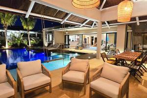 a house with a pool and a table and chairs at Golf View Villa in Roches Noires