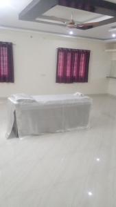 a white room with a bed and two windows at SPALON Holiday Home in Hyderabad