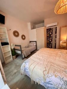 1 dormitorio con 1 cama y una estantería con botellas de vino en Le studio «des Terroux », 
