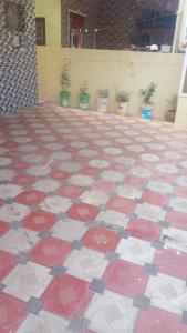 a red and white tile floor with potted plants at SPALON Holiday Home in Hyderabad