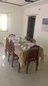 a dining room table with chairs and a table cloth at SPALON Holiday Home in Hyderabad