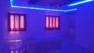 a room with red and blue lights and windows at SPALON Holiday Home in Hyderabad