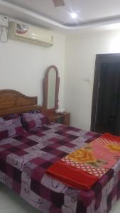 a bedroom with a bed with a checkered blanket at SPALON Holiday Home in Hyderabad