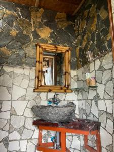 Mai Chau La Vida Homestay في ماي تشاو: حمام حجري مع حوض ومرآة