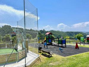 un parque infantil con una red y un banco en Casita con preciosas vistas a la montaña, en Boó de Piélagos