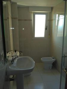 a bathroom with a sink and a toilet and a window at Piso para familias numerosas in Garray
