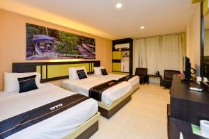 Cette chambre comprend deux lits et une télévision. dans l'établissement OYO 2487 Sampurna Jaya Hotel, à Tanjung Pinang