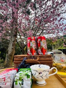 a table with baskets and cups and a tree with pink flowers at Shi Bi Hotel in Gukeng
