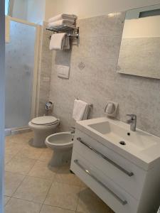 a white bathroom with a toilet and a sink at Appartamento Nonno Francesco in Ravello