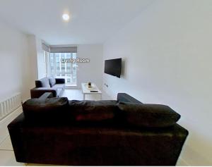 ein Wohnzimmer mit einem braunen Sofa und einem TV in der Unterkunft 3 Bed - Close to City Centre, LGI and Uni of Leeds - Long Stay Rates in Headingley