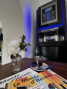 una mesa con un periódico y una máquina de Starbuck en Empire Hôtel, en Nimes
