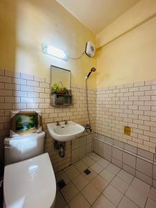 a bathroom with a toilet and a sink at Shi Bi Hotel in Gukeng