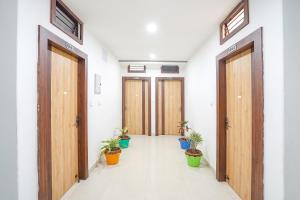 an empty hallway with wooden doors and potted plants at FabHotel Vairagi inn in Varanasi
