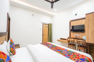 a bedroom with a bed and a table with chairs at FabHotel Vairagi inn in Varanasi