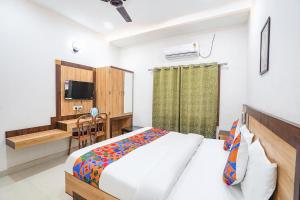 a bedroom with a bed and a desk and a television at FabHotel Vairagi inn in Varanasi