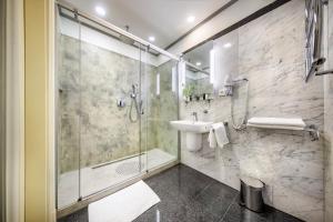 a bathroom with a glass shower and a sink at Esplanade Hotel Prague in Prague
