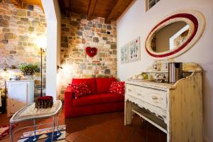 a living room with a red couch and a mirror at B&B La Casa Di Campagna in Bergamo
