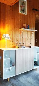 uma cozinha com um balcão branco e paredes de madeira em Le Petit Idéal em Leykaul
