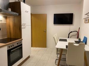 a kitchen with a table and a refrigerator and a table and chairs at FeWo WIEKO Plauen Leibnizstr. H3, DG rechts in Plauen