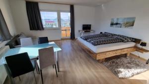 1 dormitorio con cama, mesa y comedor en Apartment- Zimmer Pernter, en Köflach