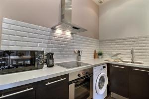 una cocina con fregadero y microondas en La Malterie Loft in old factory - Mon Groom, en La Chapelle-Saint-Luc