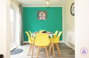 een eetkamer met een tafel en gele stoelen bij Blagdon Park, Stylish house in Bath, Free parking in Bath