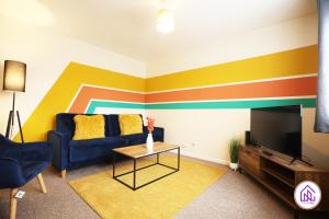 a living room with a blue couch and a colorful wall at Blagdon Park, Stylish house in Bath, Free parking in Bath
