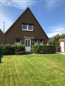 a house with a lawn in front of it at Haus Strandkrabbe in Hooksiel