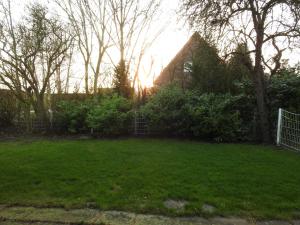 a yard with a fence and green grass at Haus Ute in Hooksiel