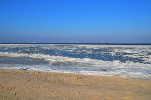 een lichaam van water met sneeuw op een strand bij Haus Deichblick 1 in Hooksiel