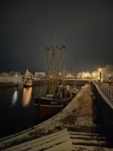 a group of boats docked at a dock at night at Fischerhaus in Hooksiel