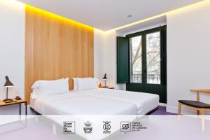 a bedroom with a large white bed and a window at SLEEP'N Atocha - B Corp Certified in Madrid