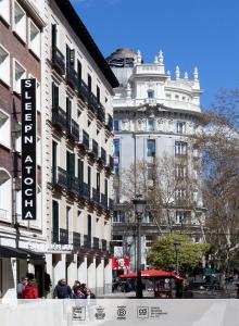 un gruppo di persone che si trovano di fronte agli edifici di SLEEP'N Atocha - B Corp Certified a Madrid