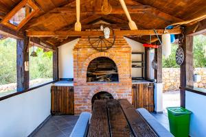 an outdoor kitchen with a brick fireplace in a house at Villa 1900 in Kornić