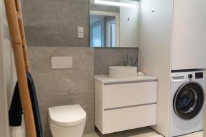 a bathroom with a sink and a washing machine at Beautiful lodge in Lofoten housing up to 6 guests! in Lyngværet