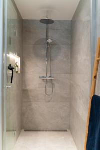 a shower with a shower head in a bathroom at Beautiful lodge in Lofoten housing up to 6 guests! in Lyngværet