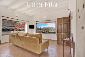 a living room with a couch and a sliding glass door at Casa Pilar, Aurora y Tarabilla en Finca Ecológica in Teguitar