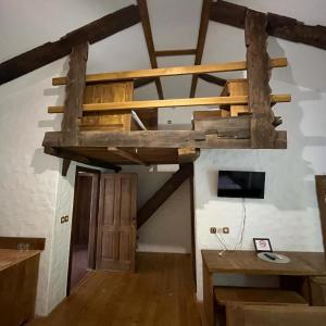 a loft bed in a room with wooden beams at Country House Marića Gaj in Grude
