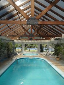 a large swimming pool with a wooden ceiling at Refugio del Solís in La Floresta