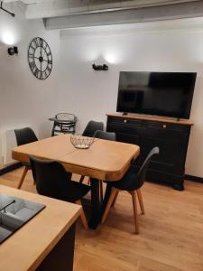 ein Wohnzimmer mit einem Holztisch und einem TV in der Unterkunft maison bonheur in Cerizay