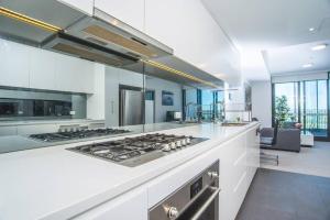 a large white kitchen with a stove top oven at Minimalism modern apartment*waterview*parking＊IGA in Sydney