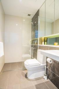 Łazienka z białą toaletą i umywalką w obiekcie Minimalism modern apartment*waterview*parking＊IGA w mieście Sydney