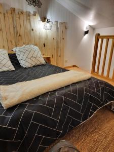 ein großes Bett in einem Zimmer mit Holzwänden in der Unterkunft maison bonheur in Cerizay