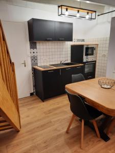a kitchen with a wooden table and a dining room at maison bonheur in Cerizay +8 photos