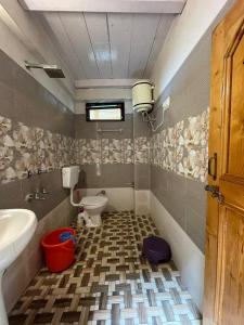uma casa de banho com um WC, uma banheira e um lavatório. em Kiran Home Stay em Shoja